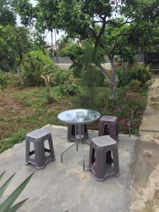 a table with two stools and a table and a table and chairs at Cico Guest House in Batumi