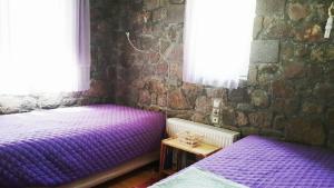 two purple beds in a room with a brick wall at Holiday Home in Sfendouri, Aegina in Sfendoúrion