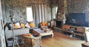 a living room with a couch and a television at Holiday Home in Sfendouri, Aegina in Sfendoúrion