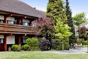 a house with a tree in front of it at Campanile Maubeuge in Maubeuge