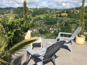 2 weiße Stühle auf einer Terrasse mit Aussicht in der Unterkunft Suite panoramique à Tulle in Tulle