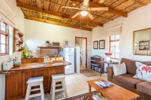 a kitchen and living room with wooden ceilings at Elfen Cottage in Prince Albert