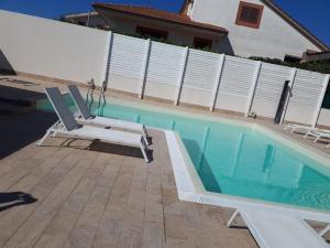 a pool with two lounge chairs next to a house at Archiammare Sea in San Lorenzo