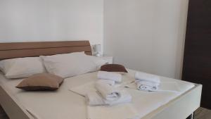 a white bed with towels and pillows on it at Apartment Skavo in Baška Voda