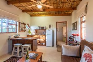 a kitchen and living room with wooden ceilings at Elfen Cottage in Prince Albert