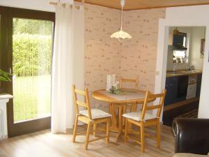 y cocina con mesa de comedor y sillas. en Haus am Wald, en Hillscheid