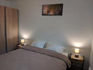 a bedroom with a bed with two lights on two tables at Terrasses de Malmedy H&H in Malmedy