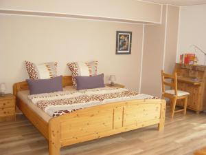 Schlafzimmer mit einem Holzbett, einem Schreibtisch und einem Stuhl in der Unterkunft Haus am Wald in Hillscheid