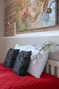 1 cama con 2 almohadas blancas y negras y una pintura en Villa Kadriorg Hostel en Tallin