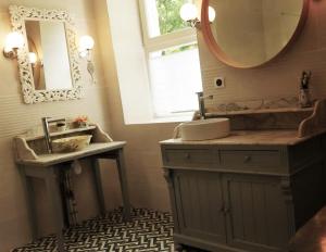 La salle de bains est pourvue d'un lavabo et d'un miroir. dans l'établissement Bed & Breakfast - La closerie de la Fuye, à Ballan-Miré