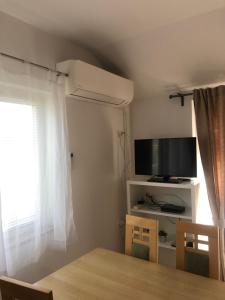 a room with a table and a tv and a window at Apartment Laura in Lopar