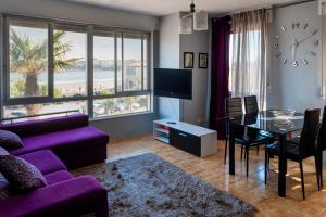 ein Wohnzimmer mit einem lila Sofa und einem Tisch in der Unterkunft Apartamento A pie de Playa in Miño