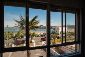 ein Fenster mit Blick auf einen Parkplatz in der Unterkunft Apartamento A pie de Playa in Miño