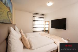 a bedroom with a white bed and a flat screen tv at Bären in Hechingen