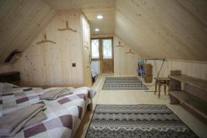 a bedroom with two beds in a wooden house at Еко Дім з СОЛОМИ in Solochin