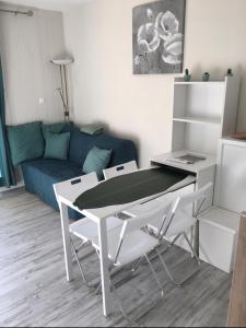 a table and chairs in a living room with a couch at Studio rénové balcon ensoleillé et calme in La Londe-les-Maures