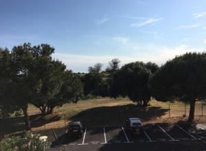 two cars parked in a parking lot with trees at Studio rénové balcon ensoleillé et calme in La Londe-les-Maures