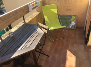 a green chair sitting next to a table and a bench at Studio rénové balcon ensoleillé et calme in La Londe-les-Maures