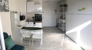 a kitchen with a table and chairs in a room at Studio rénové balcon ensoleillé et calme in La Londe-les-Maures
