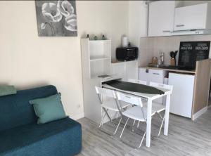 a living room with a table and a kitchen at Studio rénové balcon ensoleillé et calme in La Londe-les-Maures