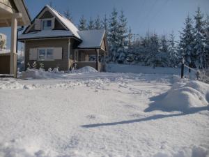 ウストロンにあるLawendowa Dolinaの雪に覆われた家の前の私道