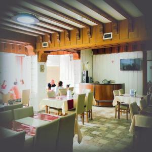 a group of people sitting at tables in a restaurant at Hotel Otsneba in Kvariati