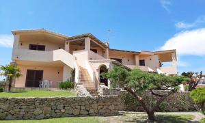 una grande casa con un muro di pietra di La Costa Mare a Arzachena