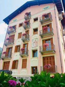 un bâtiment rose avec des boîtes de fleurs et des balcons dans l'établissement Villa Teresa, à Limone Piemonte