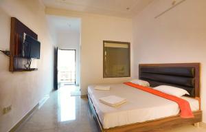 a bedroom with a bed with an orange blanket on it at Hotel Tapovan Cottage in Rishīkesh