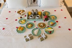 a tray of breakfast foods on a bed at Hotel Spa Nau Royal in Camburi
