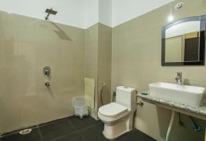 a bathroom with a toilet and a sink and a mirror at Hotel Tapovan Cottage in Rishīkesh