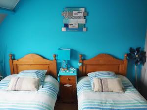 dwa łóżka siedzące obok siebie w sypialni w obiekcie Le Clos du Carpe Diem w mieście Cambligneul