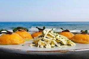 a plate of food with pasta and oranges on it at Hotel Spa Nau Royal in Camburi