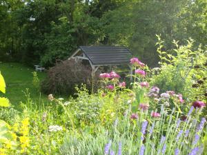 um jardim com flores e um gazebo ao fundo em Lawendowa Dolina em Ustroń