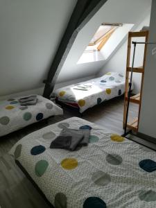 a attic room with two beds and a window at L'appart Audomarois in Saint-Omer