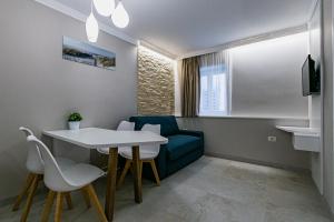 Cette petite chambre comprend une table et un canapé bleu. dans l'établissement AnvaDe Piran, à Piran