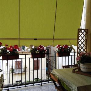 Un balcón con una mesa con flores. en B&B SoleLuna della Solidarietà, en Palermo
