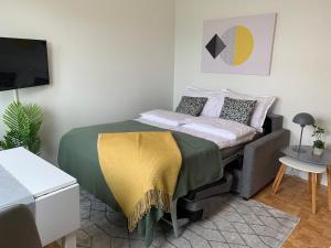 a bedroom with a bed with a yellow blanket on it at FIVE Apartments in Tromsø