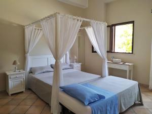 a bedroom with two beds with curtains and a window at B&B Li Ccoti in Cannole