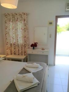 a bedroom with a bed with two towels on it at Andreas and Petrinela Rooms in Triovasálos
