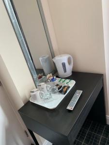 a table with a tray with cups and a remote control at Royal Hotel in Dingwall +50 photos