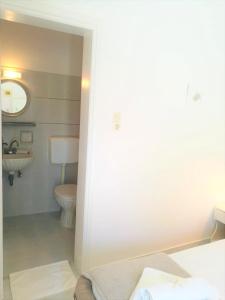 y baño con aseo y lavamanos. en Andreas and Petrinela Rooms, en Triovasálos