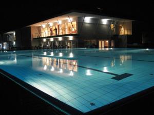 a large swimming pool in a building at night at Szépia Bio and Art Hotel in Zsámbék +42 photos