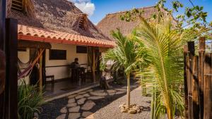 a man sitting at a table outside of a house at Vibra Guesthouse Popoyo in Popoyo