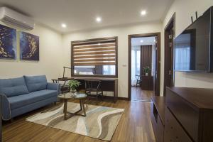 a living room with a blue couch and a table at Newsky Luxury Hotel & Apartment in Hanoi