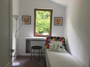 Zimmer mit einem Bett, einem Fenster und einem Stuhl in der Unterkunft Vila Scriitorilor Sinaia in Sinaia