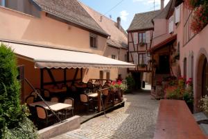 an alley with tables and chairs in a building at La Griffe à Foin au Restaurant raisin D'or in Mittelbergheim