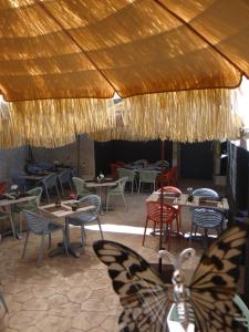 ルムーランにあるLes Glycinesの蝶のテーブルと椅子が並ぶレストラン