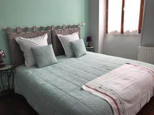 a bedroom with a large bed with pillows at AUX ROSIERS in Salies-de-Béarn