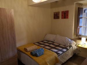 ein kleines Schlafzimmer mit einem Bett mit zwei Kissen darauf in der Unterkunft Estudio en la Plaza de Casalarreina in Casalarreina
